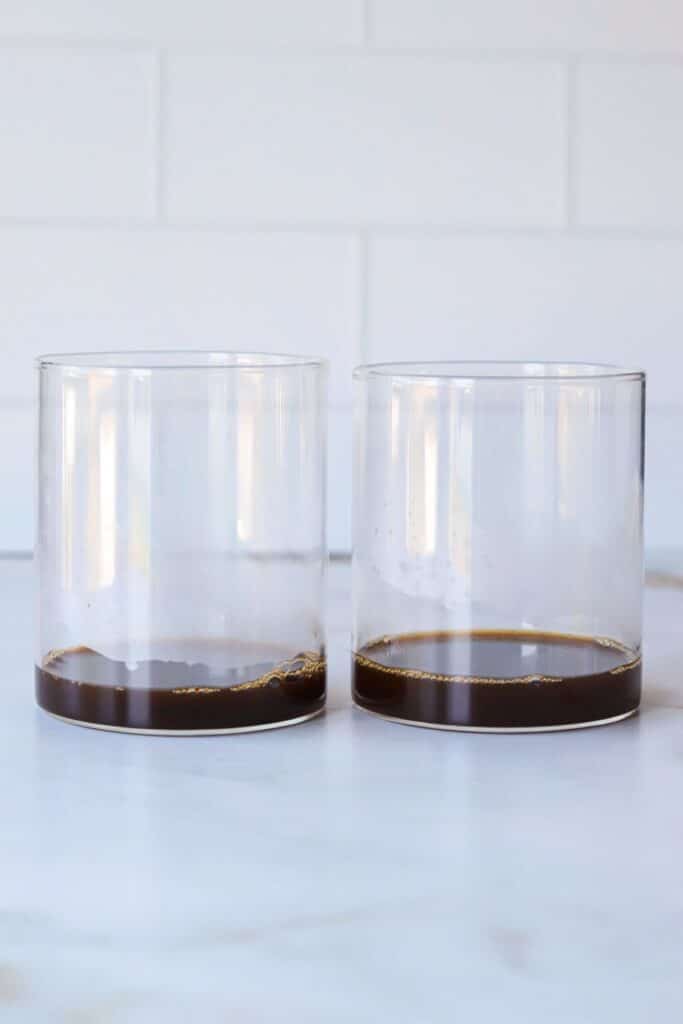 Two small glass containers with coffee.