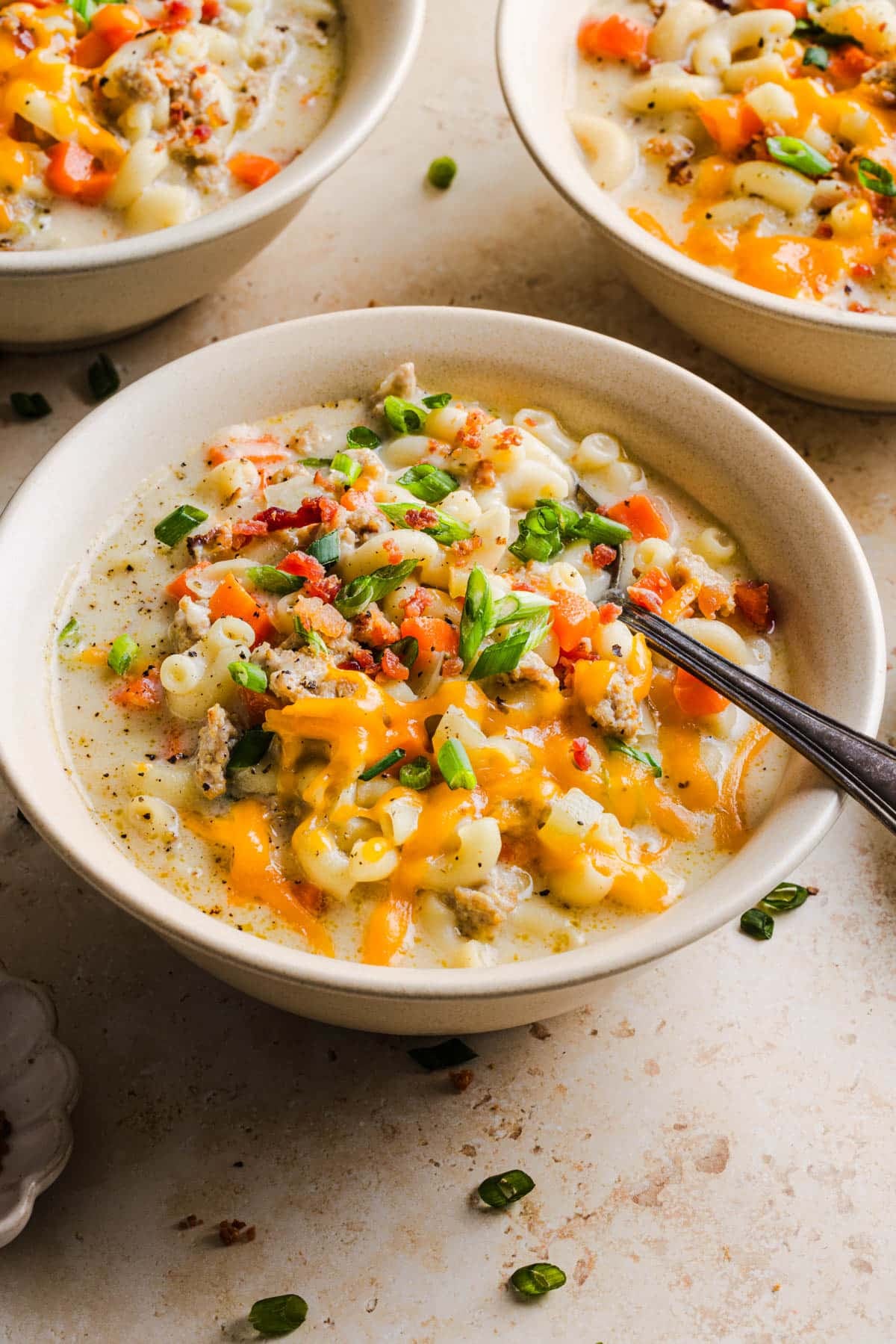 Cheeseburger macaroni soup in a bowl with a spoon on a countertop for serving.