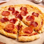 Cottage cheese pizza with pepperoni on top sitting on a piece of brown parchment paper