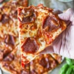 A close up shot of cottage cheese pizza crust being held up.