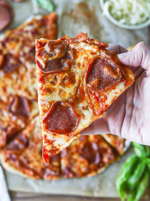 A close up shot of cottage cheese pizza crust being held up.