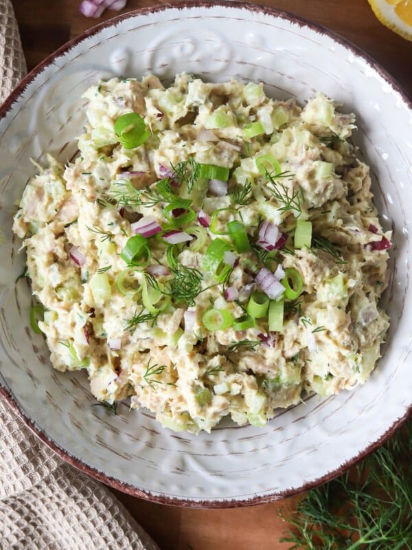 Cottage cheese tuna salad garnished with herbs and red onion in a bowl.