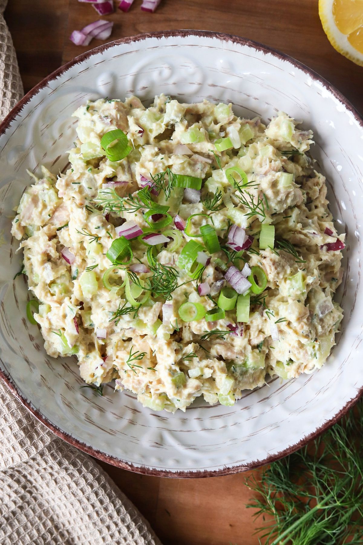 Cottage cheese tuna salad garnished with herbs and red onion in a bowl.