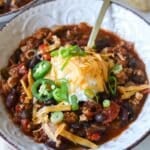 Ground chicken chili recipe topped with sour cream, cheddar cheese and jalapeños.