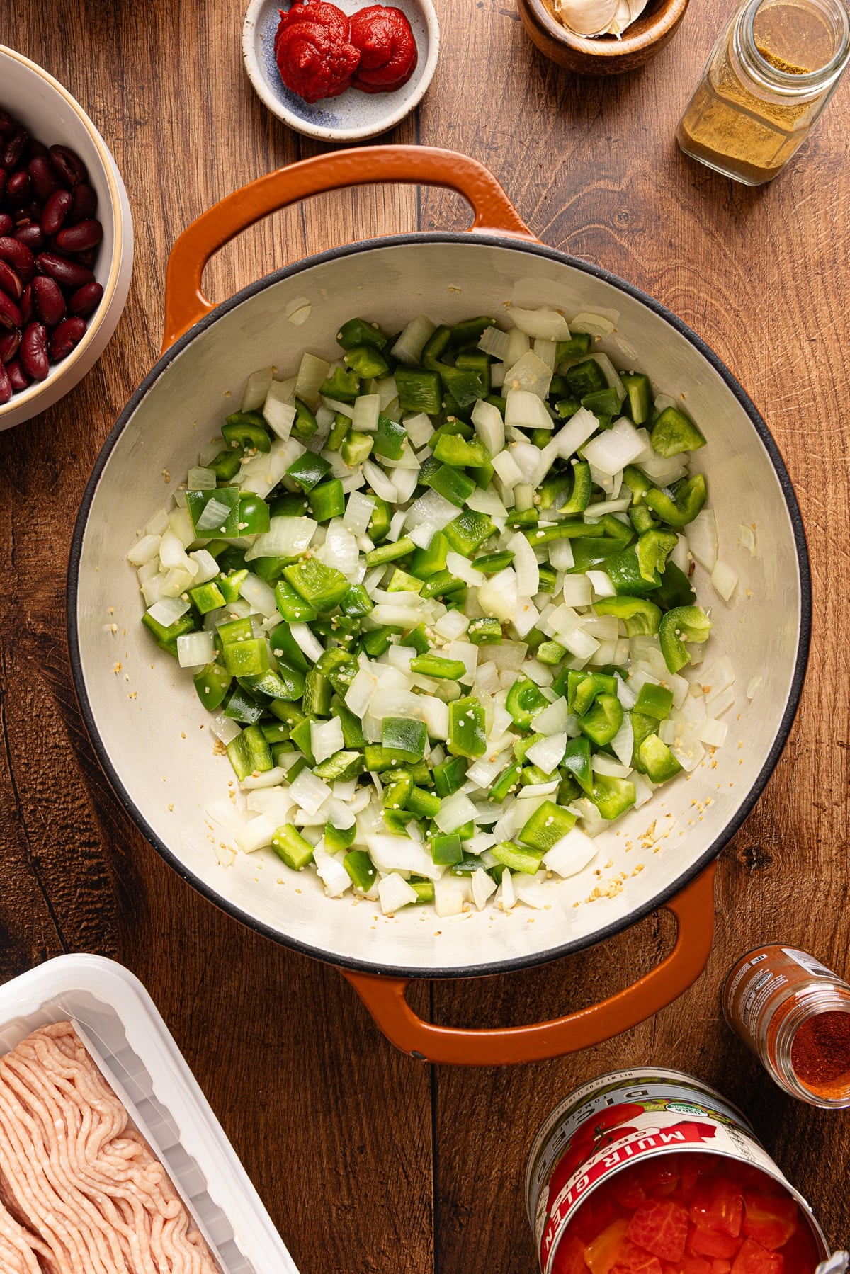 Chopped bell peppers and onions in a Dutch oven .