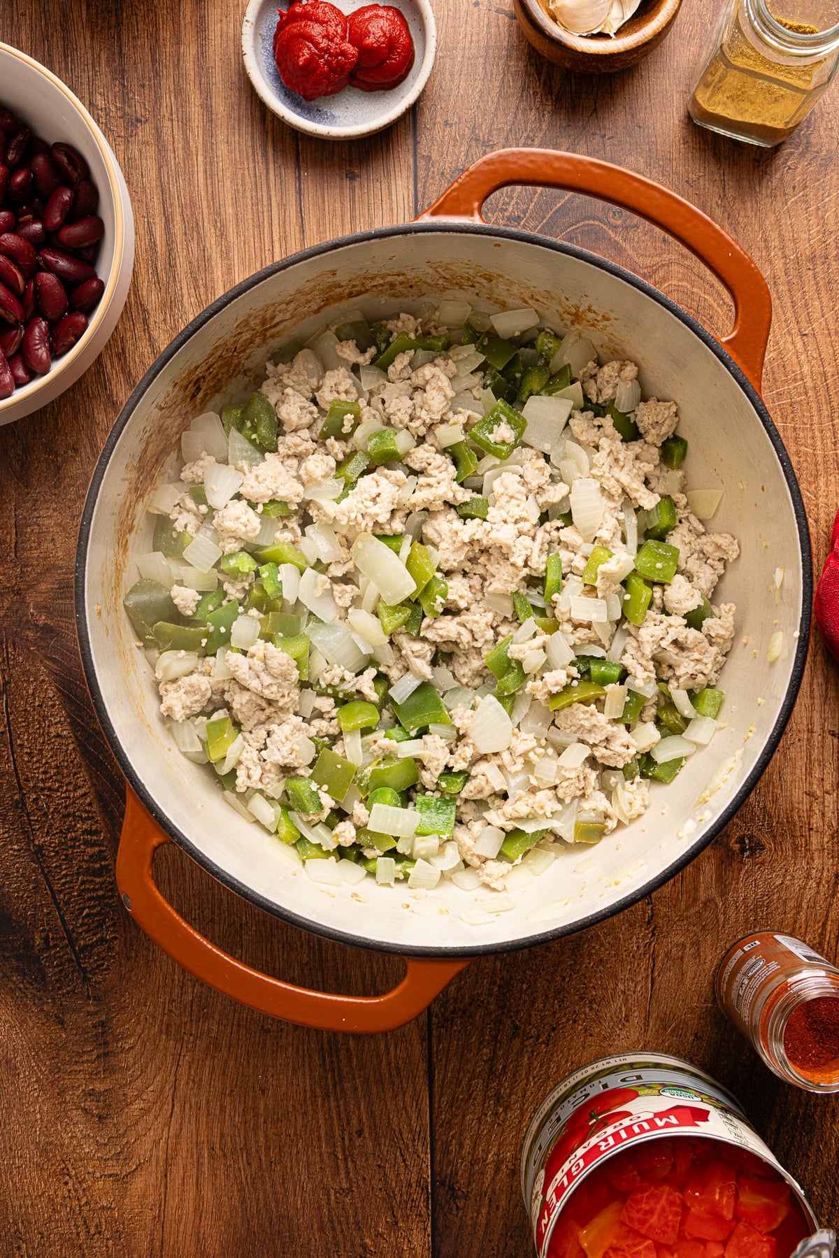 The cooked ground turkey in a Dutch oven with the cooked bell peppers and onion. 