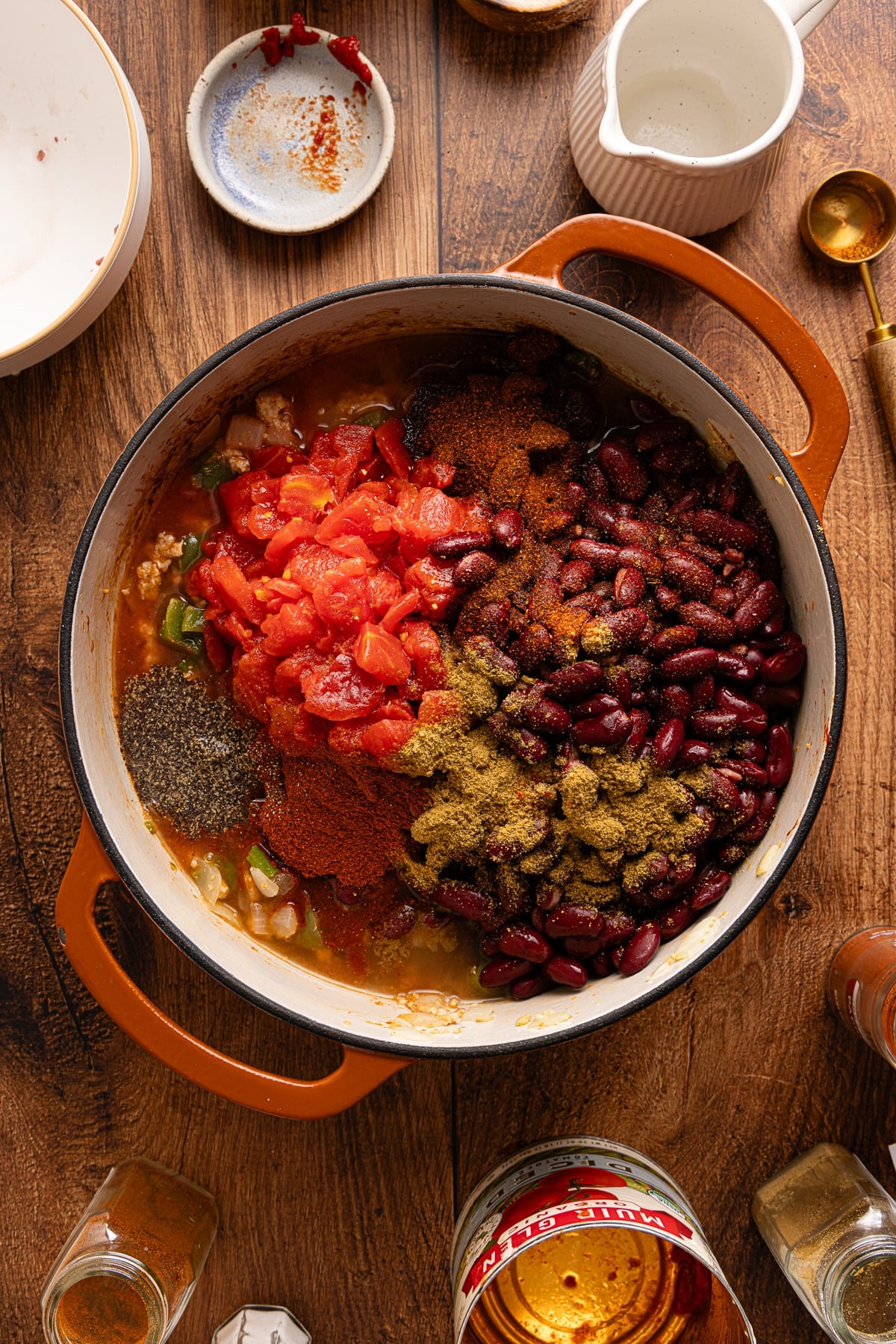 The diced tomatoes, broth, beans, and seasonings in the dutch oven with the cooked chicken and vegetable mixture.