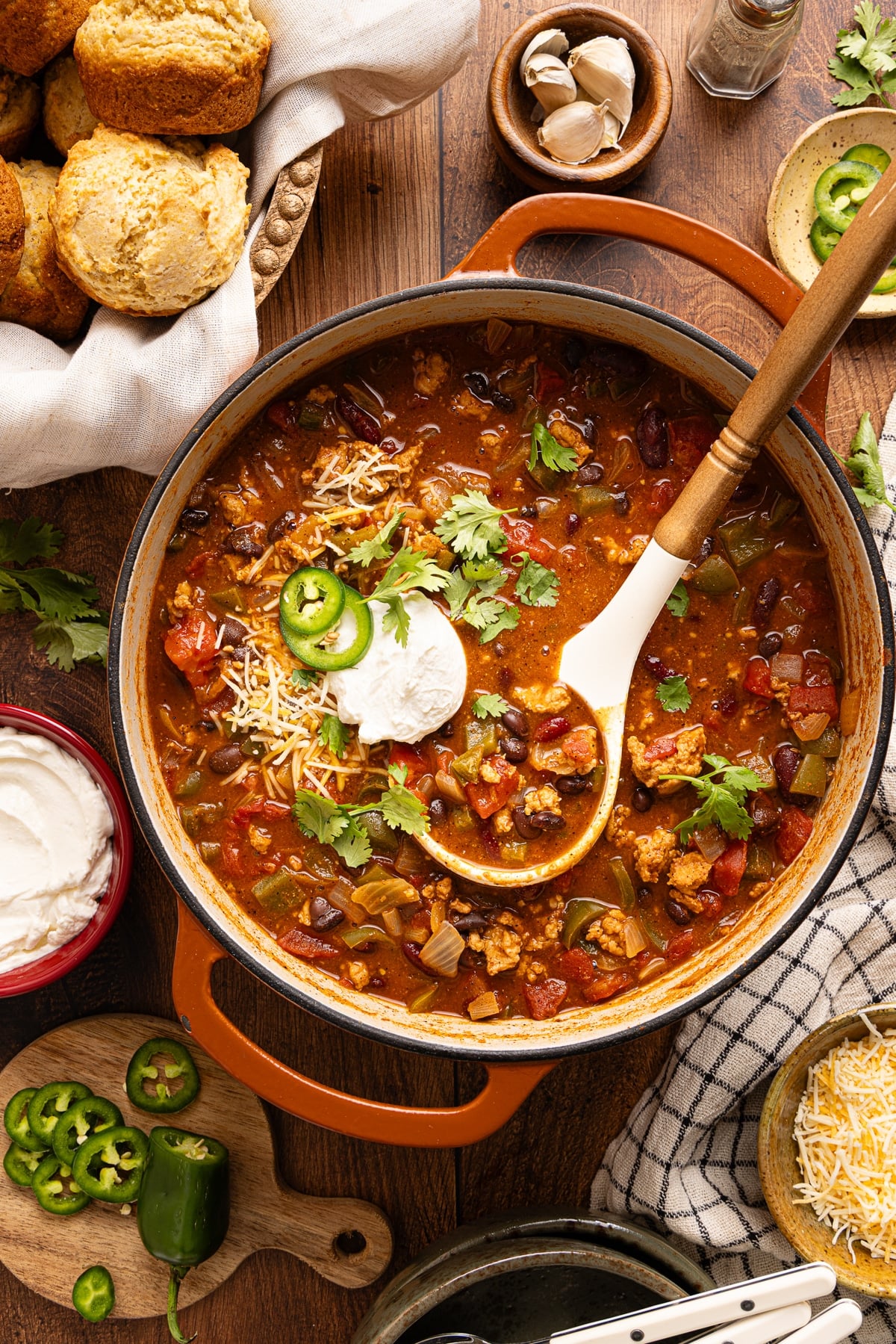 A ladle rests in a pan of hearty ground chicken chili.