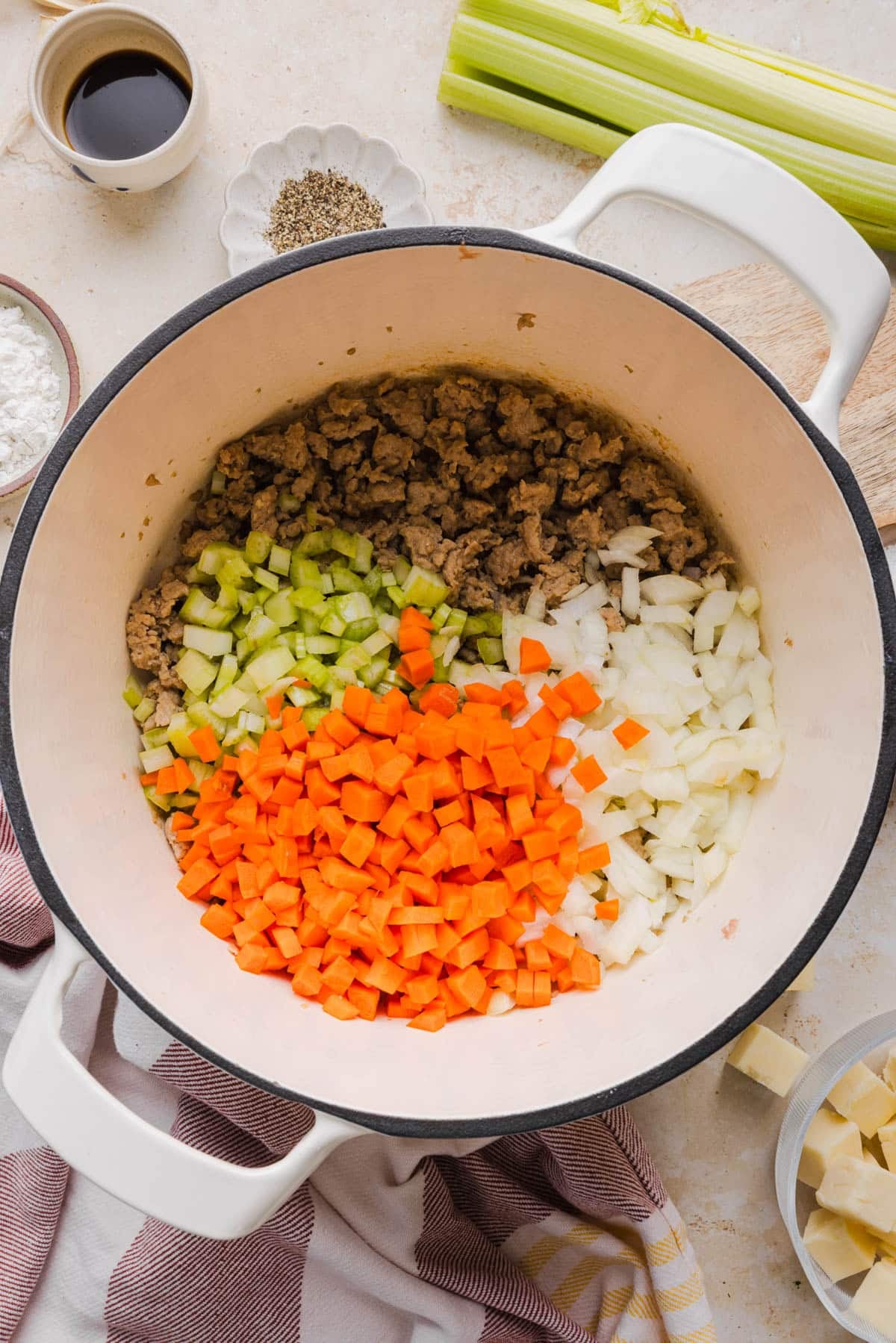 The cooked turkey, carrots, celery, and onions in a large Dutch oven for cooking.