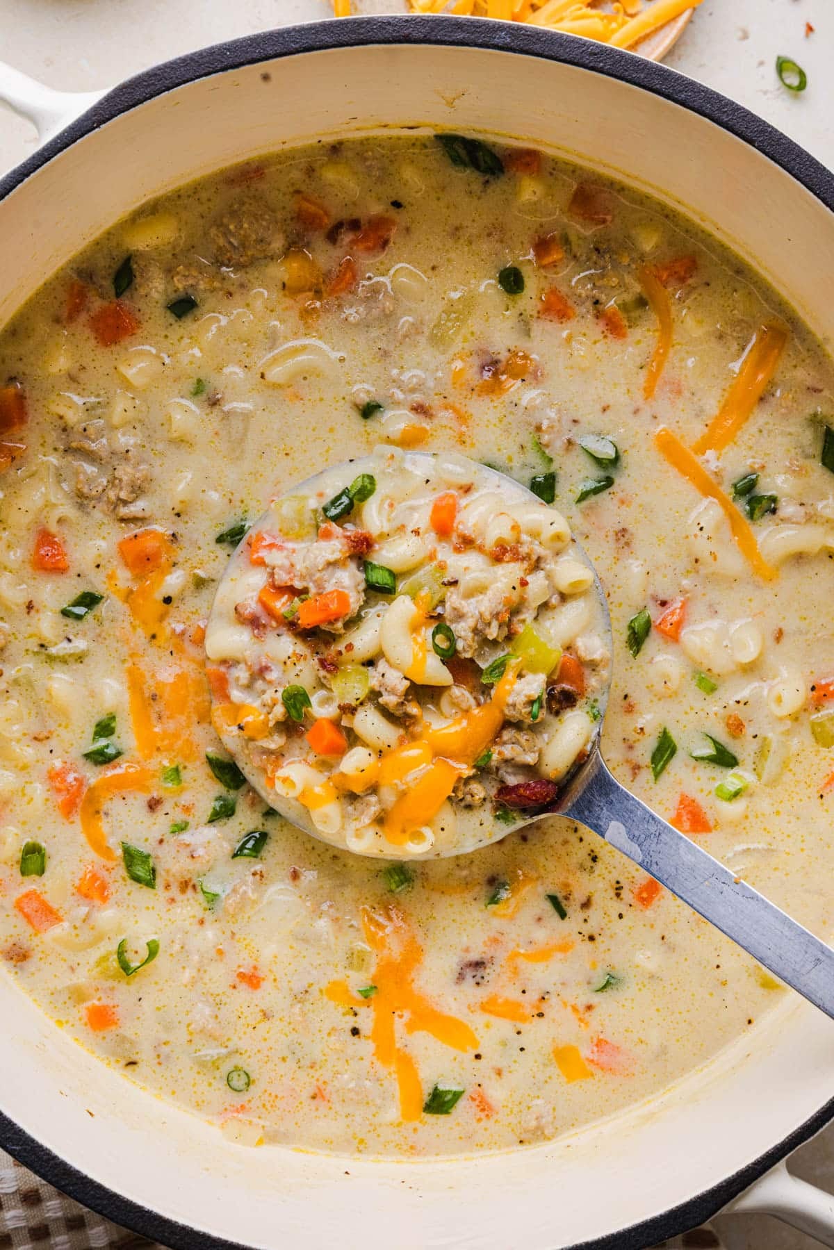 A ladle scoops up the finished soup in the pot.