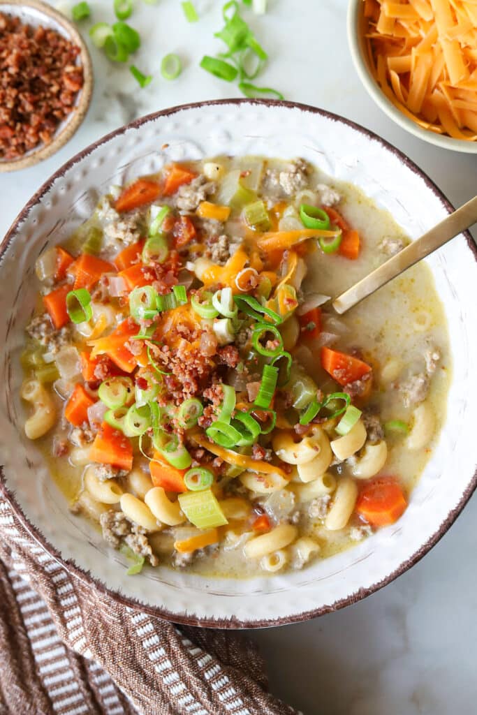 One pot cheeseburger mac soup topped with bacon crumbles and green onions.