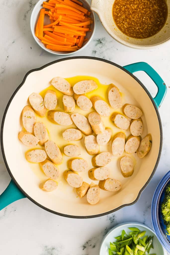Chicken sausage in a pan with olive oil.