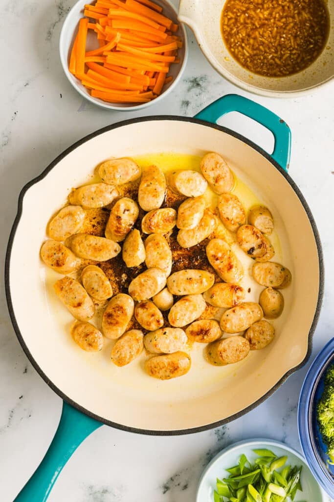 Chicken sausage cooked in a pan with olive oil.