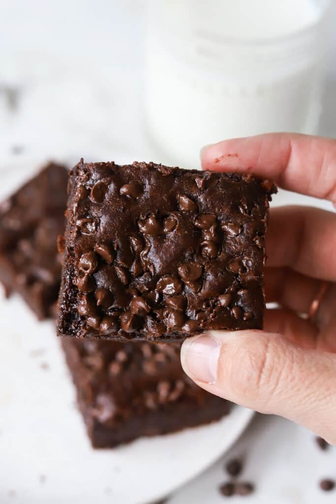 A cottage cheese brownie being held up by a hand.