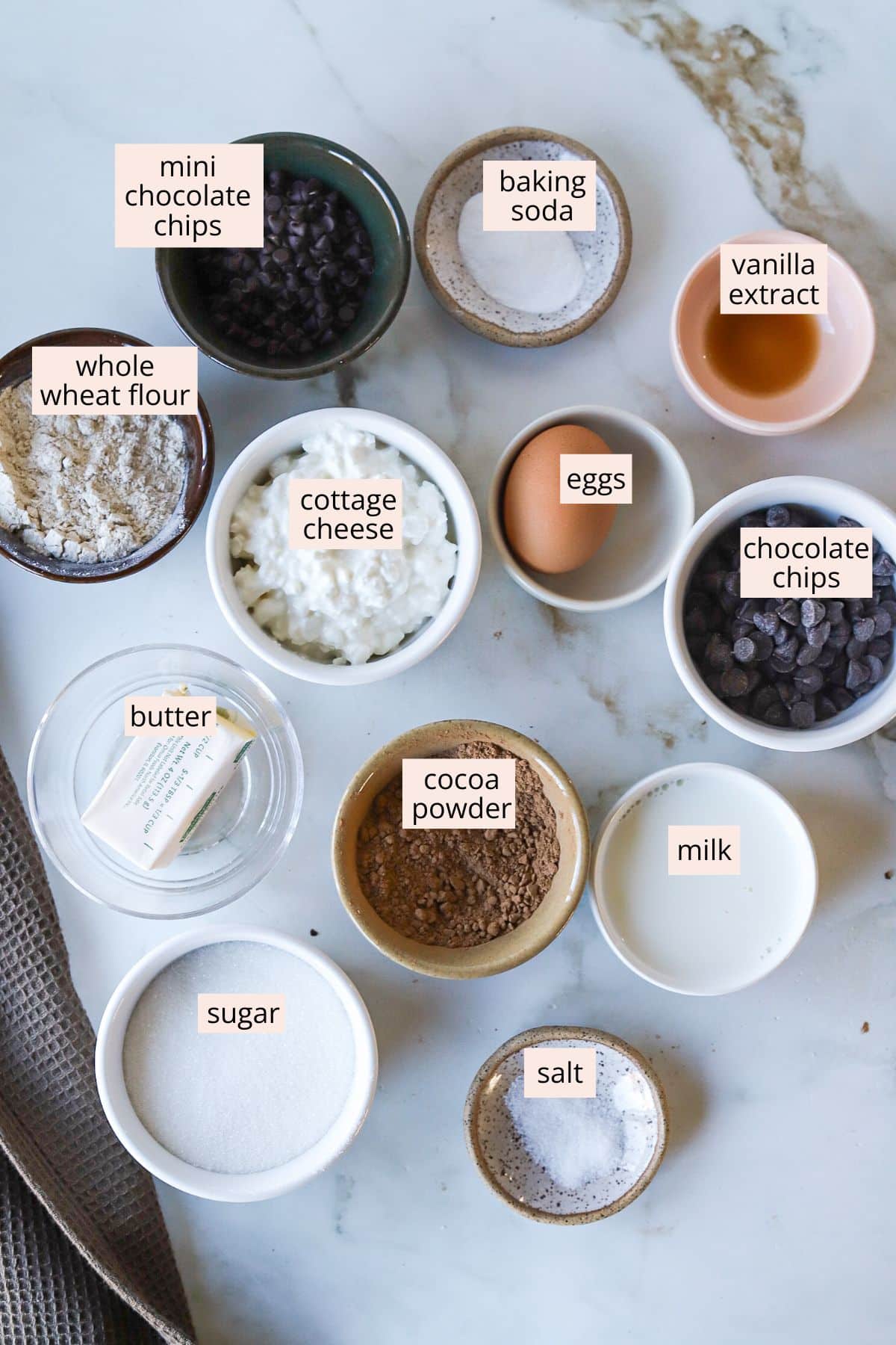 Ingredients for cottage cheese brownies on a countertop with labels.