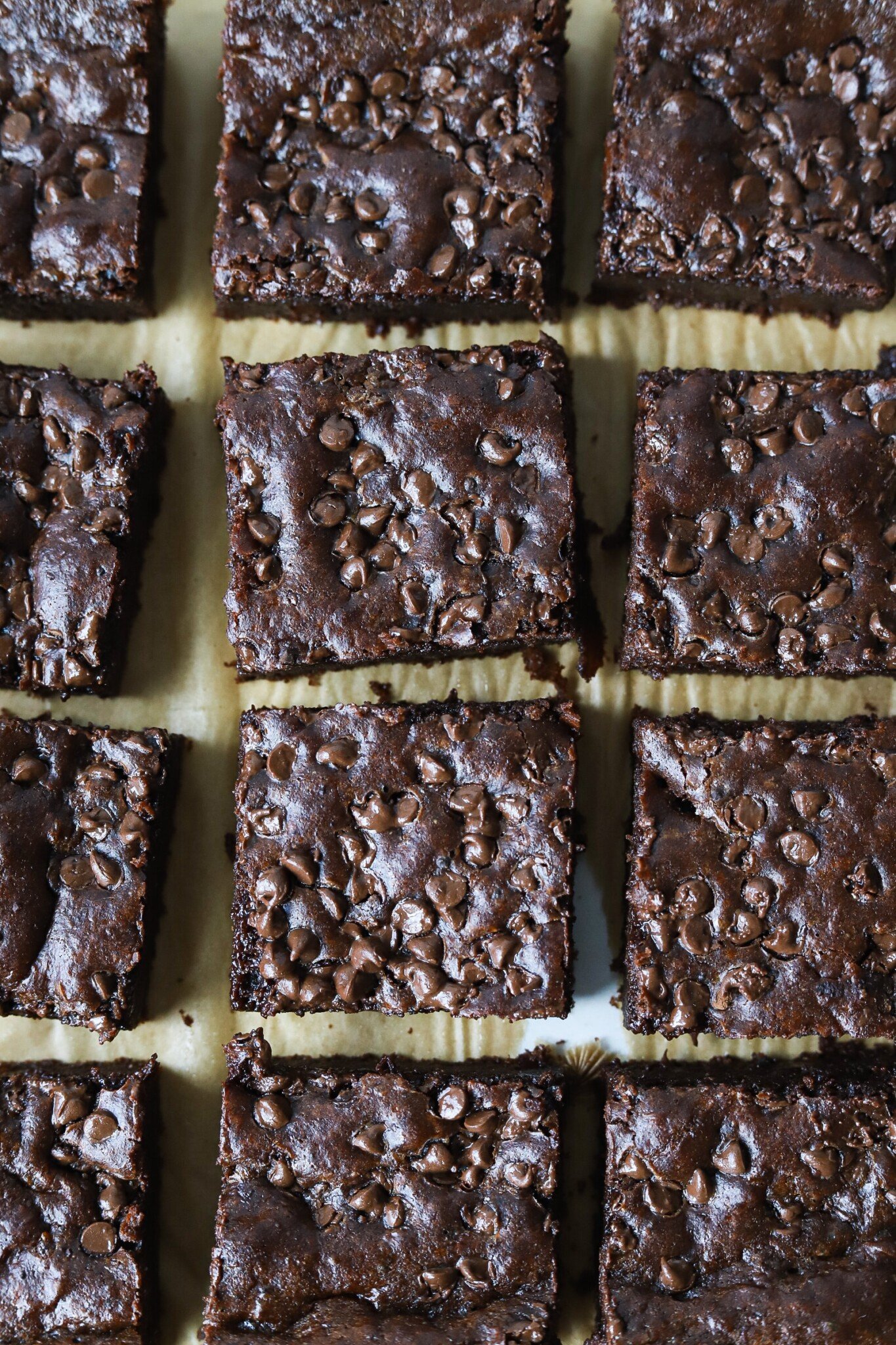 Cottage cheese brownies sliced on parchment paper.
