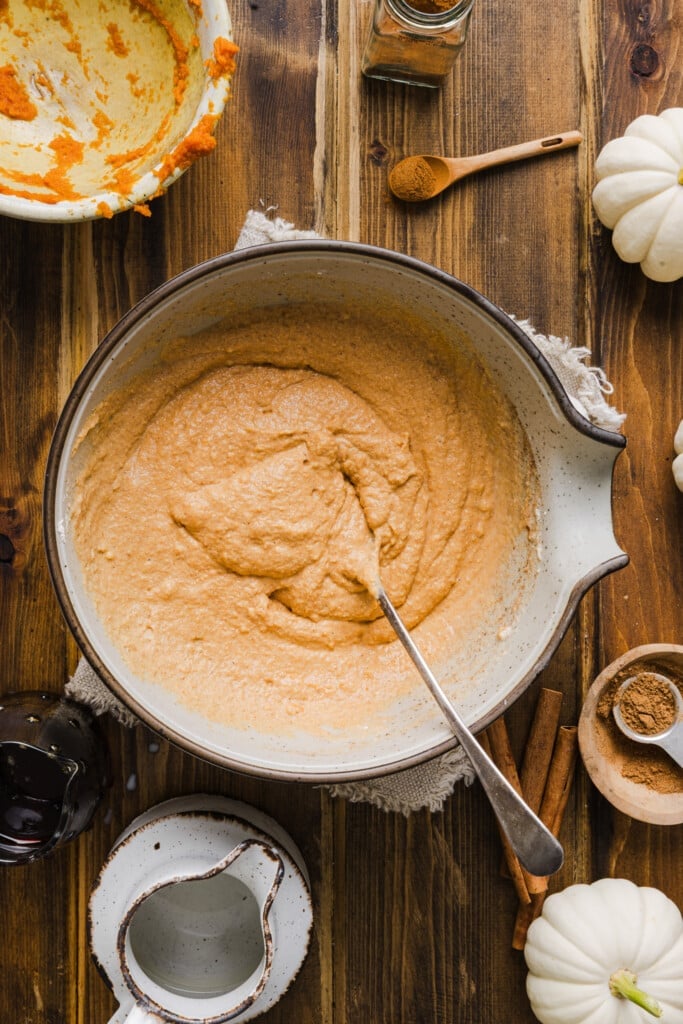 Ingredients for pumpkin pancakes with pancake mix mixed in a large bowl.