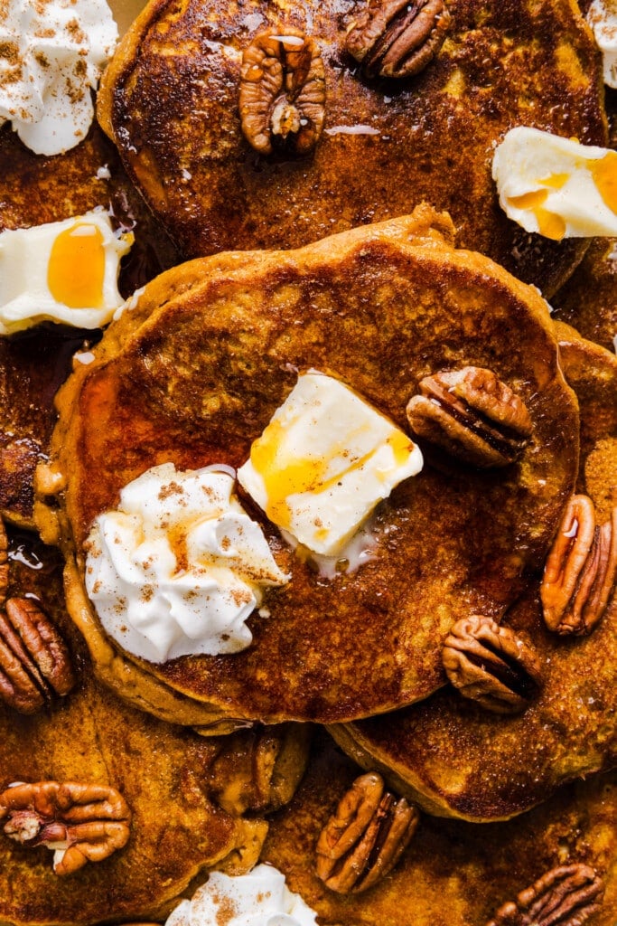 Pumpkin pancakes made with pancake mix on a platter with butter and syrup.