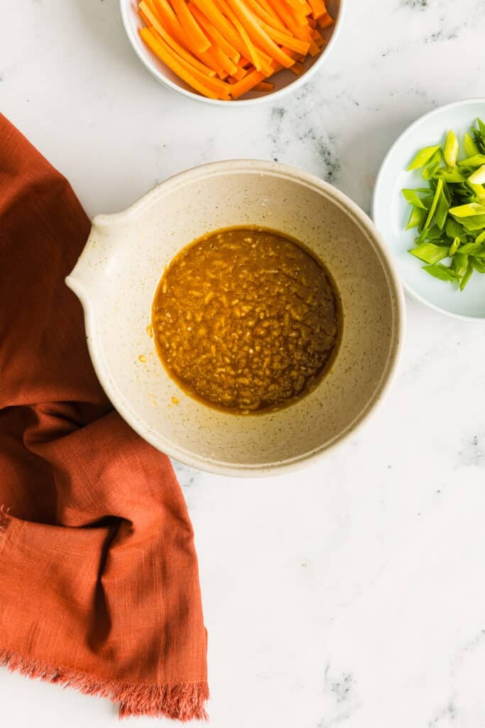 A honey garlic stir-fry sauce in a beige bowl.