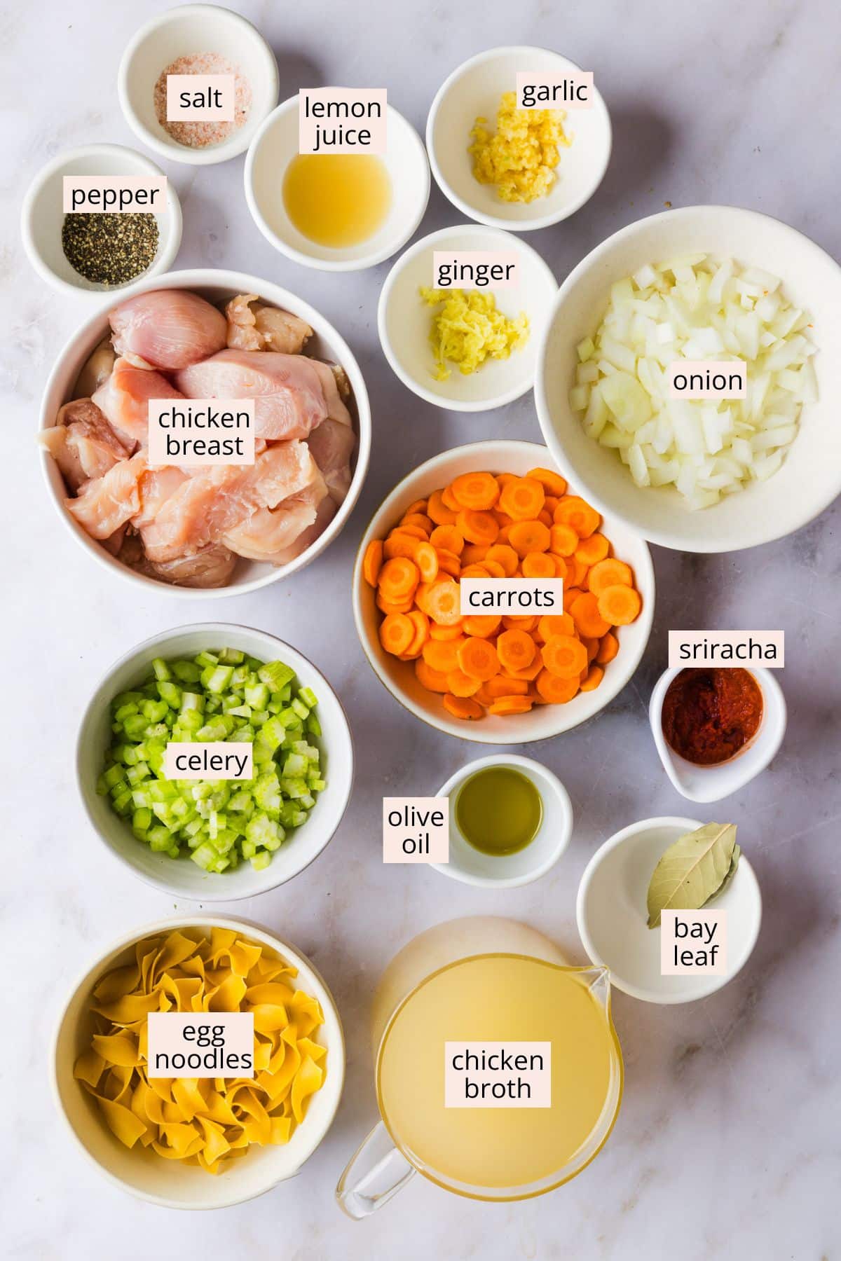 Spicy chicken noodle soup ingredients on a countertop with labels.
