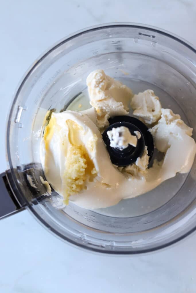 Ingredients for whipped ricotta dip in a food processor.