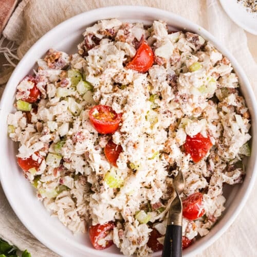 BLT chicken salad in a white bowl with a large spoon.