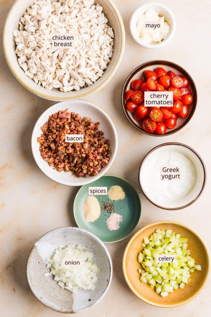 Ingredients for BLT chicken salad on a countertop with labels.