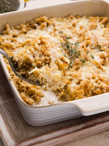 French onion soup rice in a casserole dish topped with Gruyère cheese and thyme.