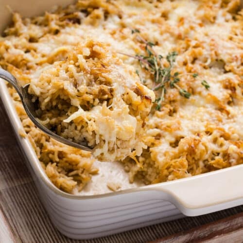 French onion soup rice in a casserole dish topped with Gruyère cheese and thyme.