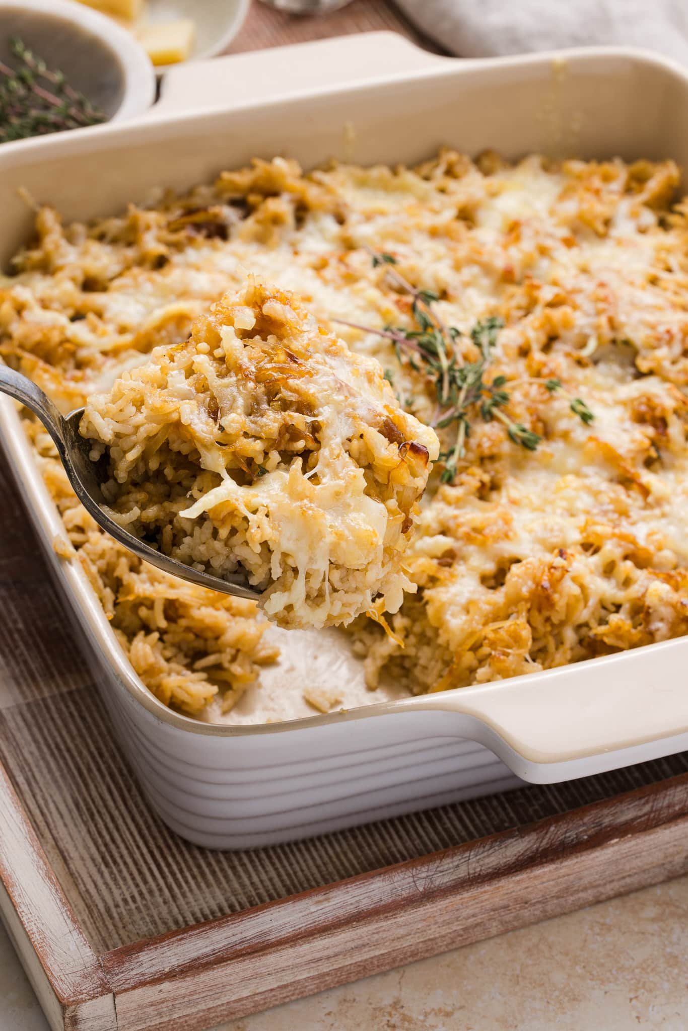 French onion soup rice in a casserole dish topped with Gruyère cheese and thyme.