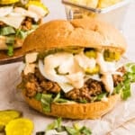 A big mac sloppy joe with big mac sauce and pickles with chips.