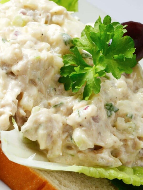Canned chicken salad on a slice of bread with lettuce.