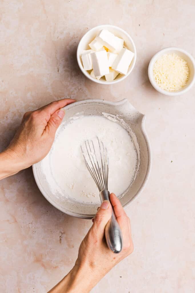 Flour and milk being mixed together in a bowl.