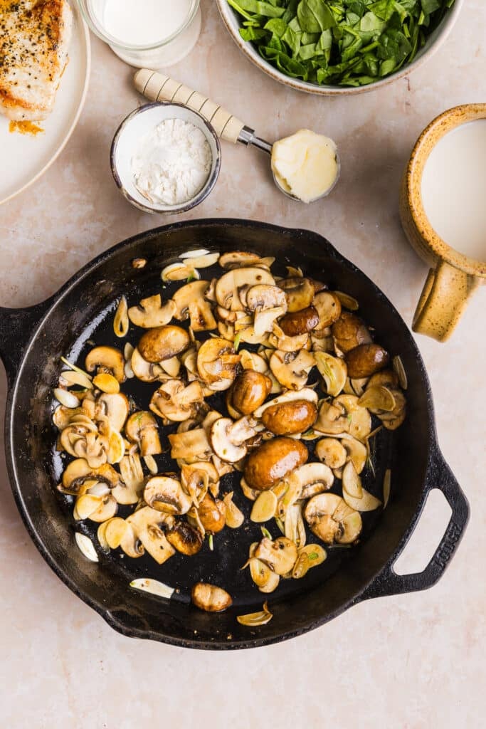Mushrooms being sauteéd in a pan.