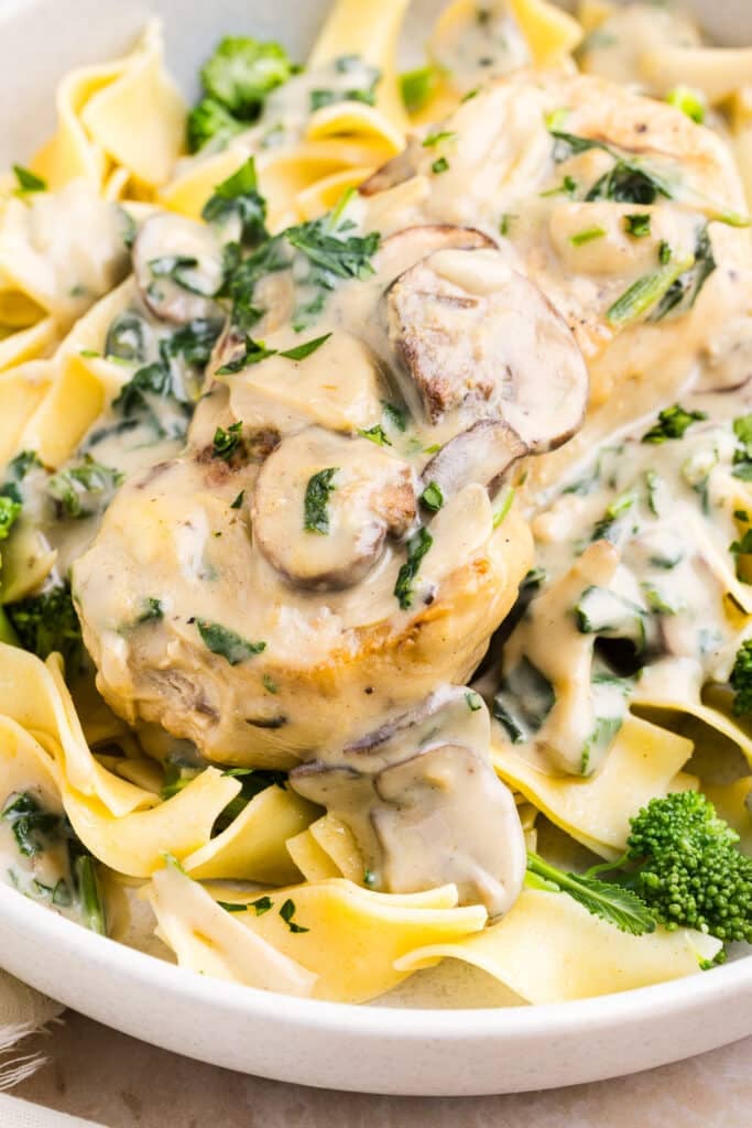 Creamy garlic pork chops on top of egg noodles with broccoli.