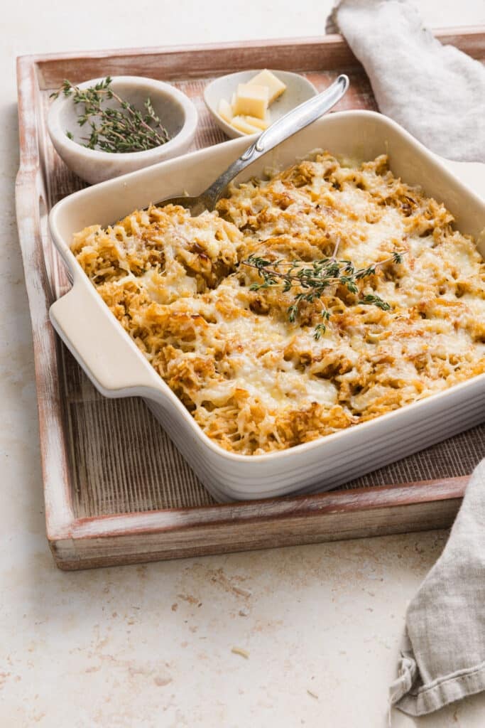 French onion soup rice in a casserole dish topped with Gruyère cheese and thyme.