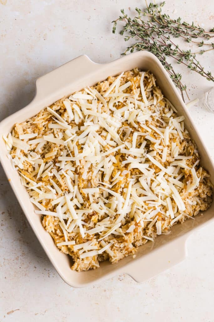 French onion soup rice in a casserole dish topped with gruyère cheese.