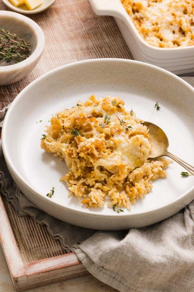 A plate of french onion soup rice garnished with thyme.