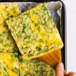 A close up shot of a slice of sheet pan eggs for sandwiches.