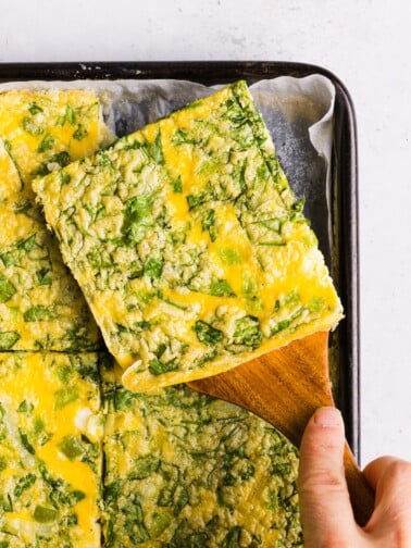 A close up shot of a slice of sheet pan eggs for sandwiches.