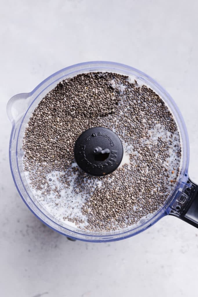 Chia seed pudding ingredients in a food processor about to be blended.