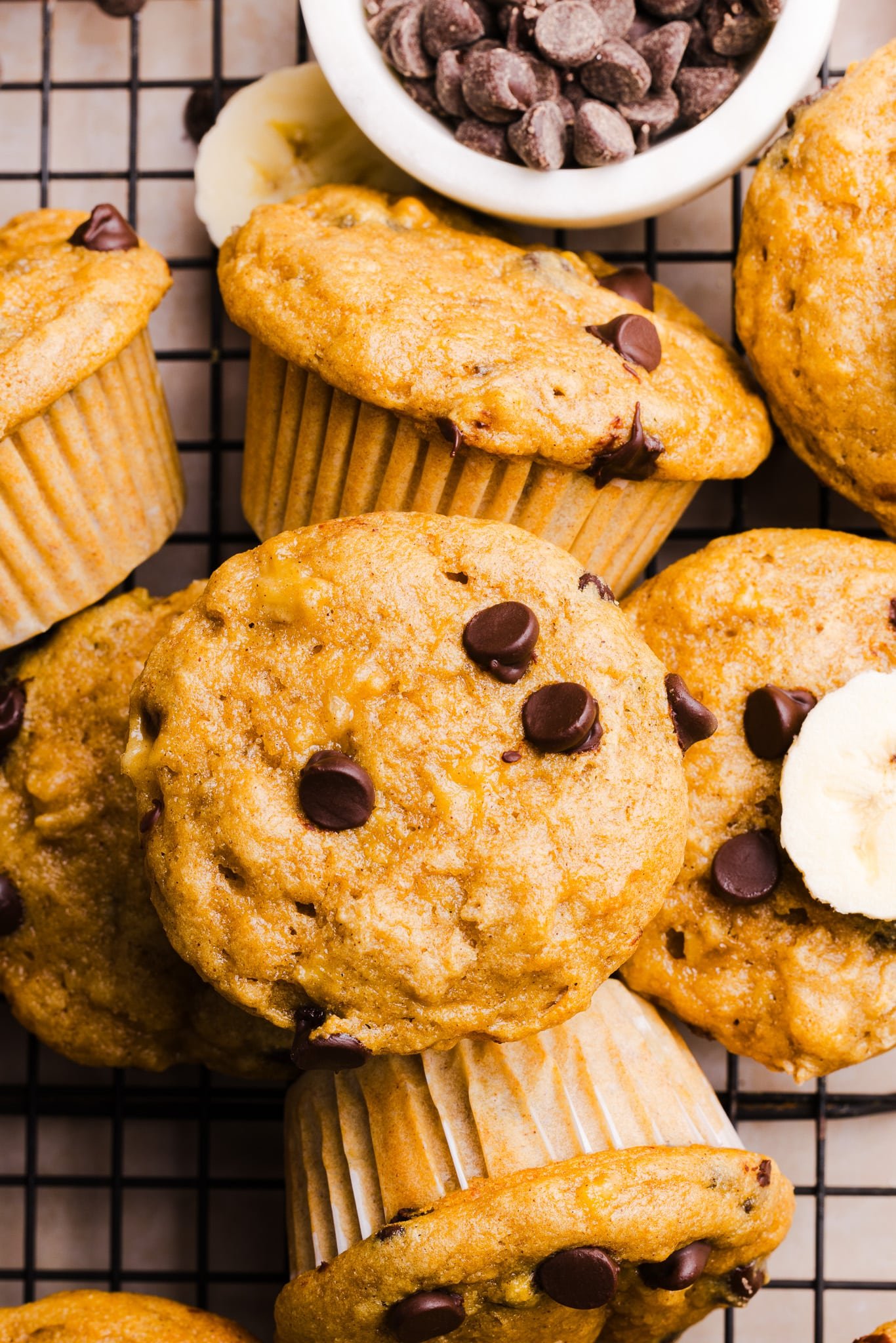 Kodiak banana muffins on a baking rack with chocolate chips.