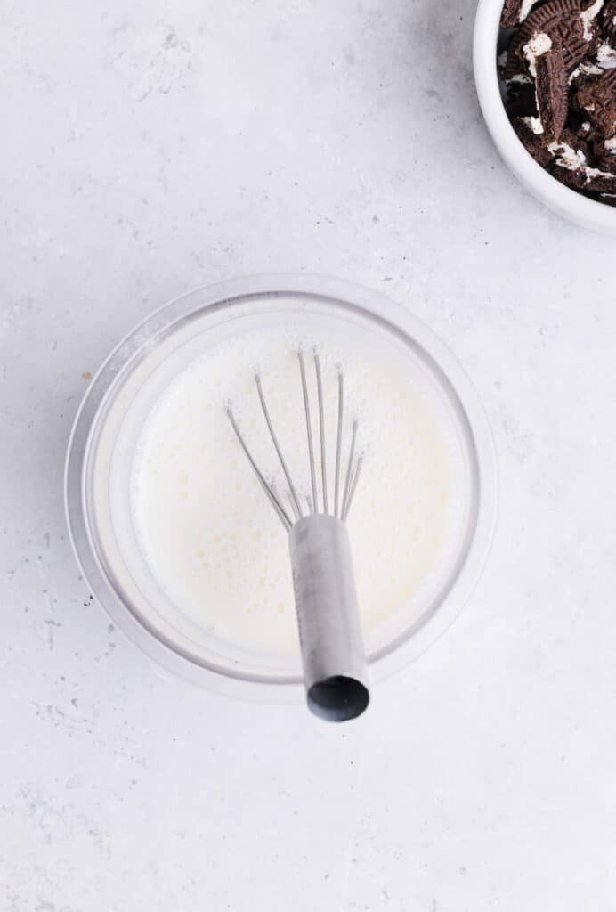 Ninja Creami oreo milkshake ingredients being whisked in the pint container.
