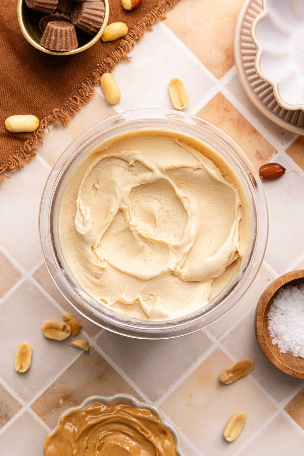 Creamy peanut butter ice cream in the ninja creami cup sitting on a countertop.