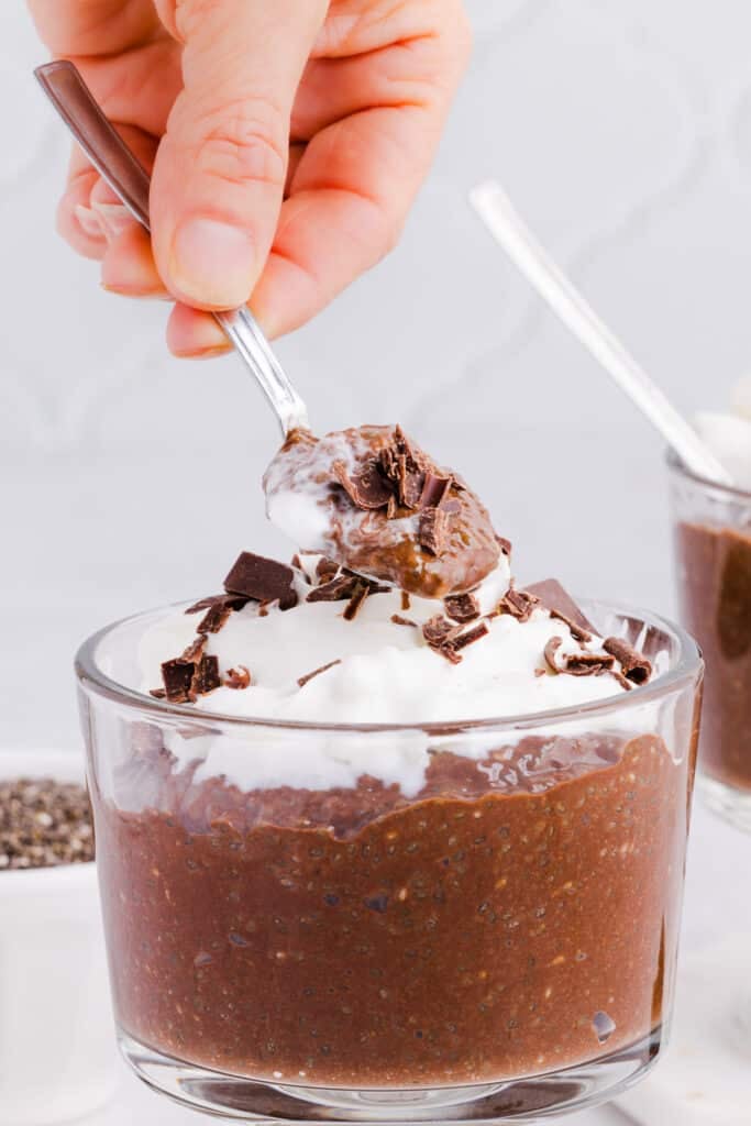 A spoon scooping out a spoonful of blended chia seed pudding.