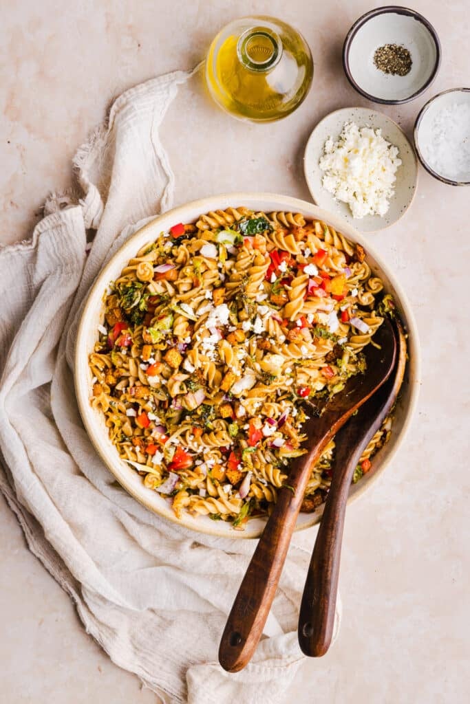 Winter pasta salad with Brussels sprouts, butternut squash and peppers in a large serving bowl.