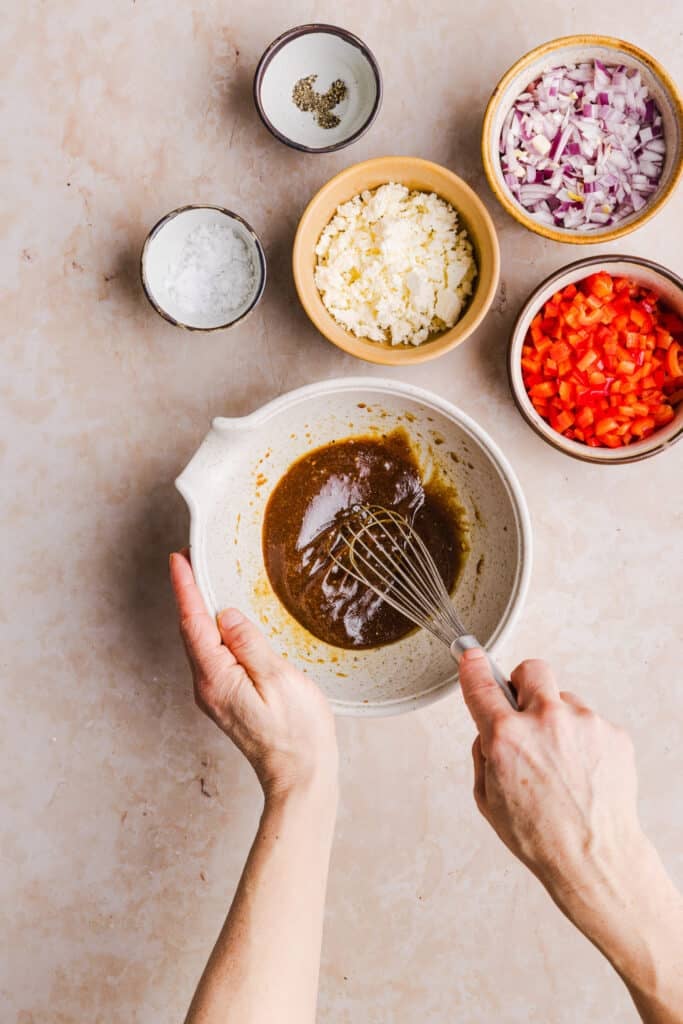 Winter pasta salad dressing being mixed in a small bowl.