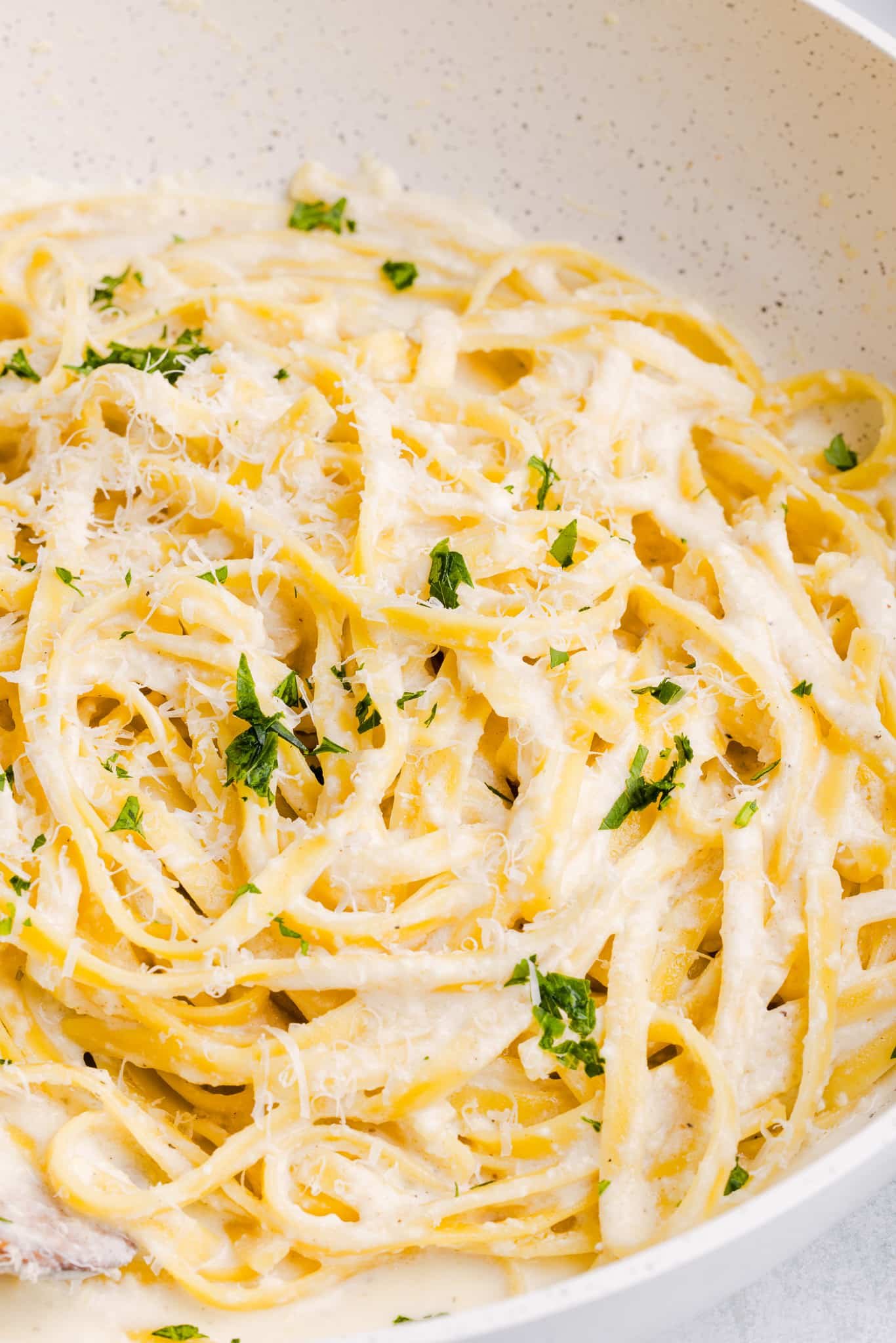 A close up shot of Greek yogurt Alfredo sauce garnished with parsley.
