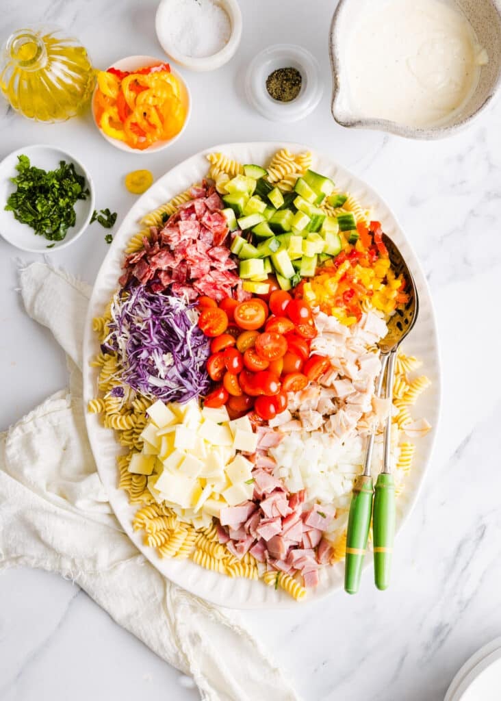 Grinder pasta salad ingredients on a plater, not yet mixed.