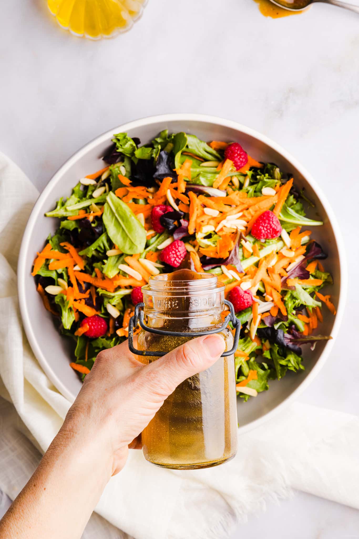 Maple balsamic dressing being poured onto a salad.